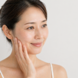 頬に手を当てて微笑む女性